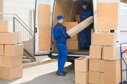 Team member loading moving equipment into a van safely